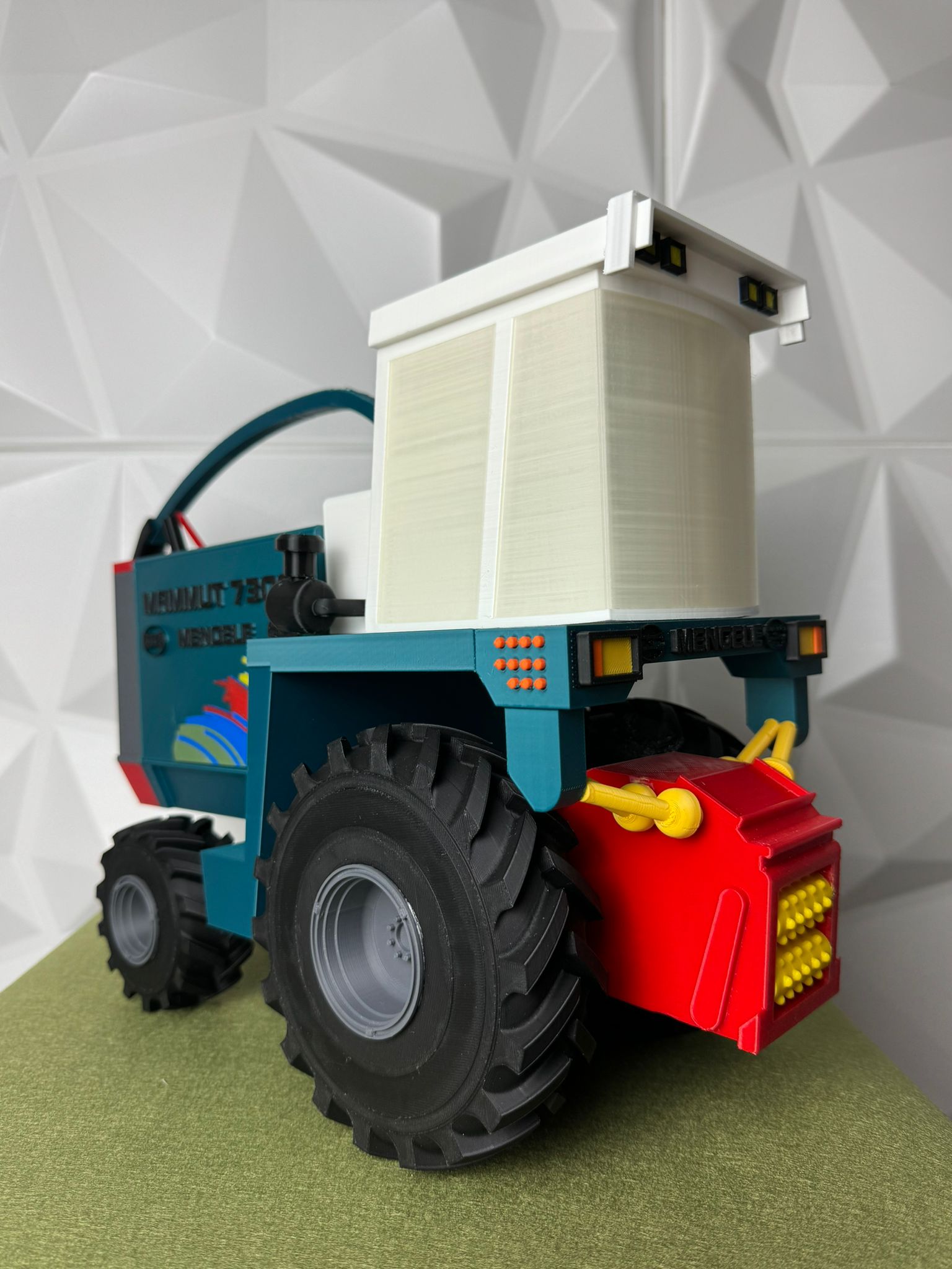 Maqueta de tractor industrial impresa en 3D con múltiples colores y detalle técnico